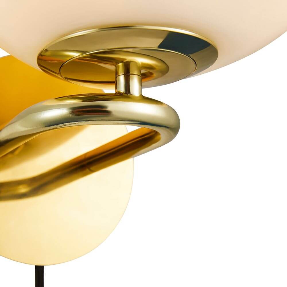 Detailaufnahme der Wandleuchte Shapes mit opalglas und glänzendem Messingfuß.