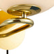 Detailaufnahme der Wandleuchte Shapes mit opalglas und glänzendem Messingfuß.