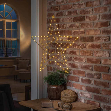 Christmas LED star with 112 light points IP20, decoratively glowing on a brick wall.
