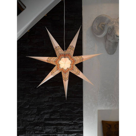 White paper star, perforated with a colorful printed pattern, 7 points, without light source, decorative hanging in a modern room.