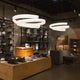LED Hängeleuchte Cyclone 7000lm Weiß im modernen Shop-Interieur mit stylischen Hüten und Accessoires.