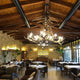XXL Chalet Geweih Kronleuchter Ø 200cm in rustikalem Restaurant mit Kamin und gemütlicher Einrichtung.