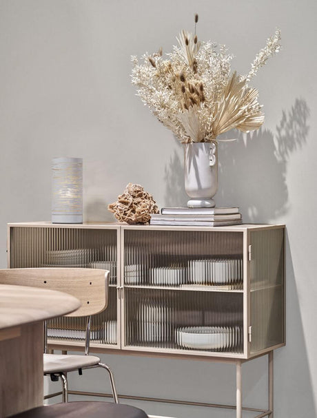 Zane bordlampe E14 Ø 10 cm på en moderne skjenk med dekorative planter og servise.