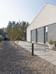 Zosia Außenwegeleuchte Dunkelgrau IP65 beleuchtet modernen Gartenweg neben einem modernen Haus.