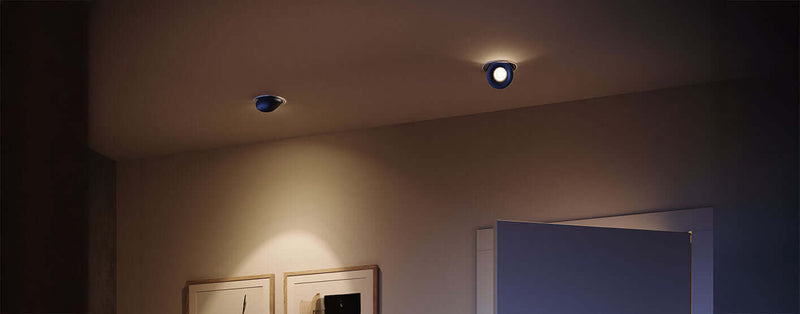 Moderne Deckenleuchten in einem stilvollen Raum mit einer geöffneten Tür und Bildern an der Wand.