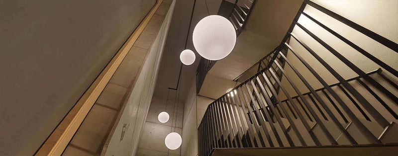 Modern staircase with spherical pendant lights illuminating the space.