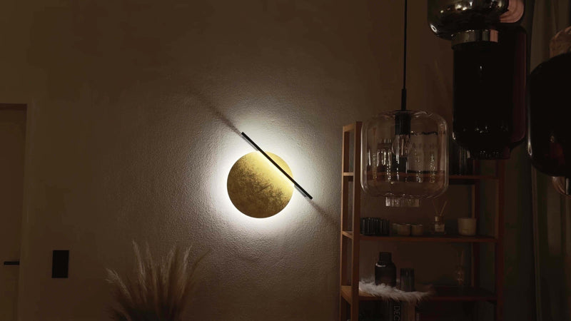 Moderne Wandleuchte in Form einer goldenen Sonne, die warmes Licht in einem stilvollen Raum ausstrahlt.