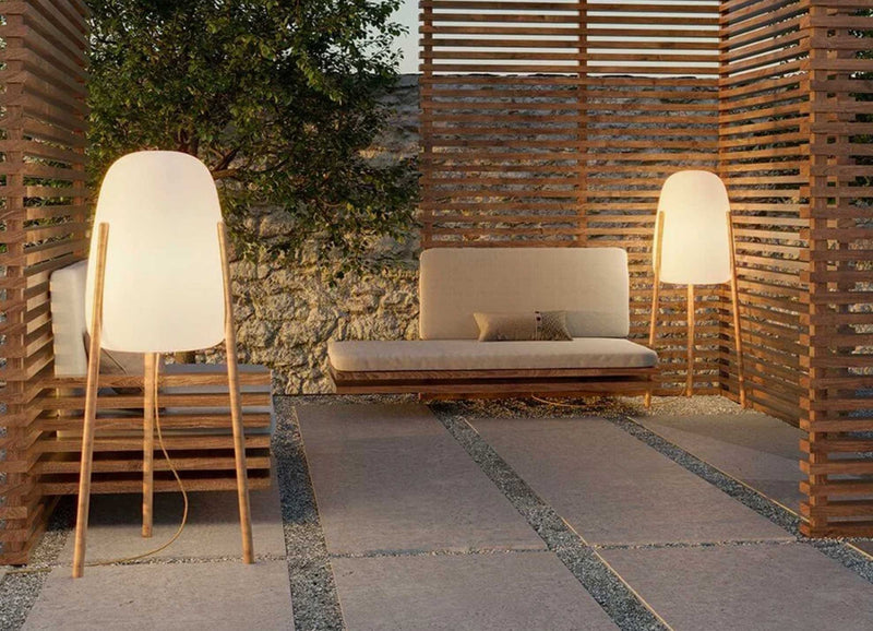 Moderne Outdoor-Lounge mit Holzlamellen, heller Sitzbank und Stehleuchten im minimalistischen Design