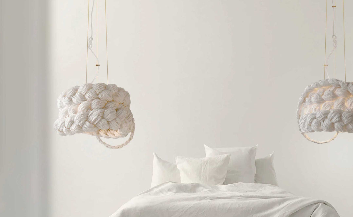 Minimalistisches Schlafzimmer mit weißen Pendelleuchten und hellem Bett