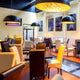 Moderne Restaurant-Inneneinrichtung mit s.luce Blister Pendelleuchten in Matt und gemütlichen Stühlen.