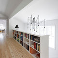 Modernes Zuhause mit Bücherregal und einzigartiger s.luce Modular Baldachin-Leuchte.