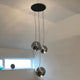 s.luce Modular Umbau bis 20 Leuchten mit drei hängenden, reflektierenden Kugelleuchten an einem Baldachin.