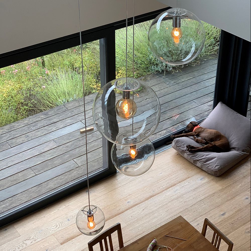 s.luce Orb glass ball pendant light above a table with a dog on a dog bed in the background.