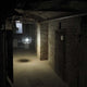 s.luce Rooms Gitter-Hängeleuchte in einem flurähnlichen Raum mit Betonwänden und schwachem Licht.