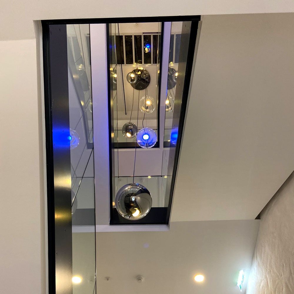 Moderne s.luce Sphere Galerieleuchte in einem Treppenhaus mit asymmetrischer Lichtverteilung.