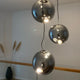 s.luce Sphere Galerieleuchte mit klaren und rauchfarbenen Glaskugeln, ideal für Treppenhäuser und Galerien.