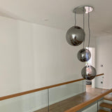 Moderne s.luce Sphere Galerieleuchte mit drei schwebenden Glaskugeln in rauchfarben, elegant im Treppenhaus.