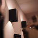 Moderne schwarze Ixa Wandleuchte an der Wand, perfekt für jede Umgebung.