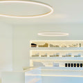 s.luce LED Ring Pendellampe im modernen Raum, minimalistische Beleuchtung über Regalen mit Kosmetikprodukten.