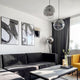 Moderne Wohnzimmeransicht mit s.luce Progress Galerieleuchte und stilvollem Interieur in schwarz-weiß.