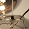 Detailaufnahme der s.luce Sphere Pendelleuchte mit Glaskugel und Kabelaufhängung.