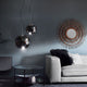 Moderne s.luce Sphere Pendelleuchte in rauchfarbenem Glas, arrangiert über einem eleganten Wohnzimmer.