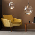 s.luce Sphere Hängeleuchte aus Glas mit E27 Leuchtmittel und modernem Design über gelbem Sessel