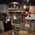 Moderne s.luce Sphere Pendelleuchte aus Glas in einem stilvollen Esszimmer mit Blumen und dekorativen Elementen.