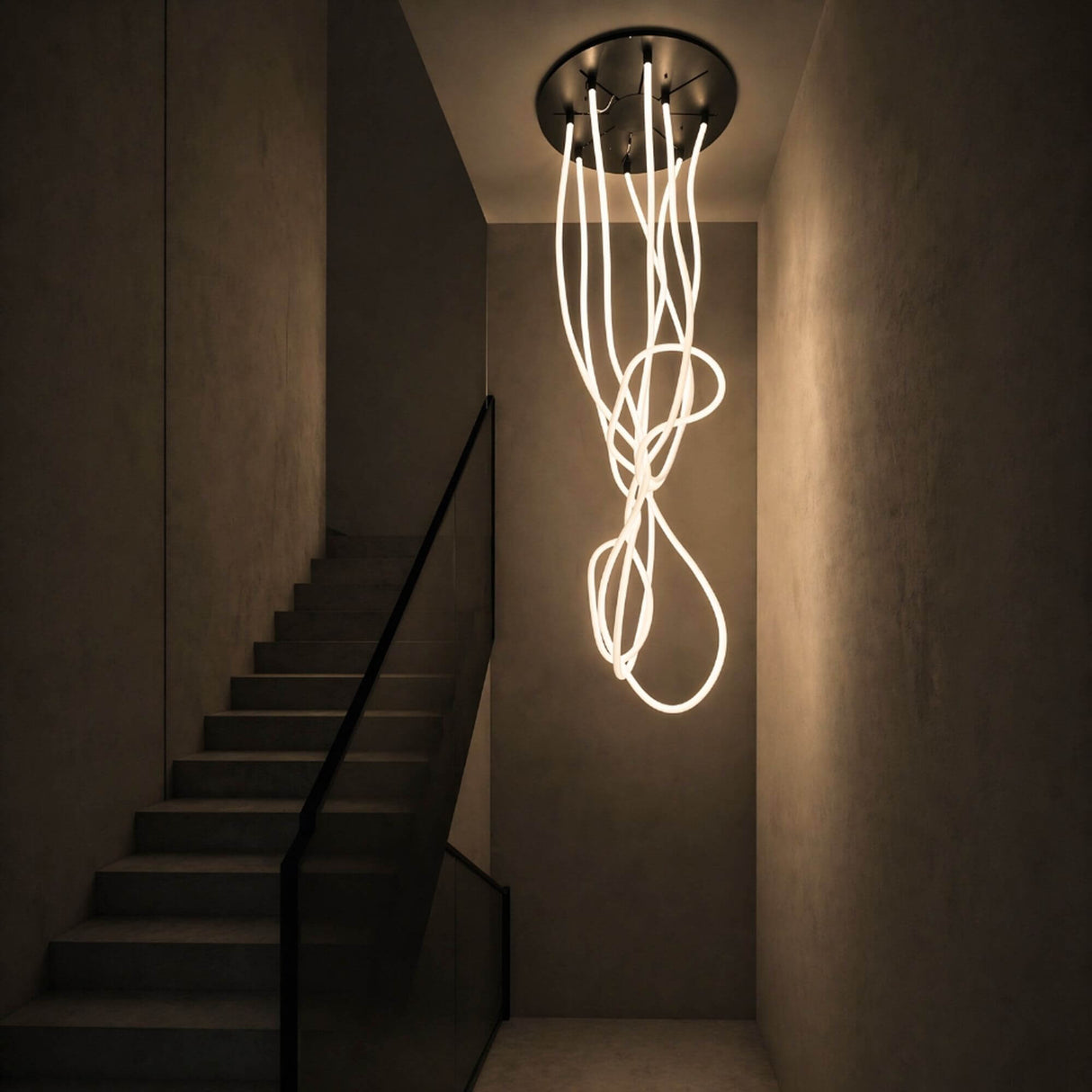 s.luce Arion organische Flex LED Hängelampe Licht-Schlauch Warmweiß im modernen Treppenhaus mit kreativen Lichtformen.