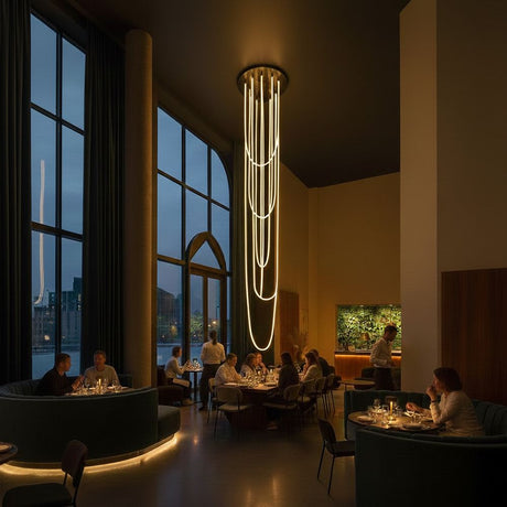 s.luce Arion organische LED Galerieleuchte XXL Schlauch Warmweiß in stilvollem Restaurant-Interieur bei Abendlicht.