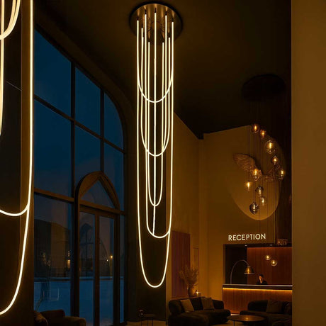 s.luce Arion organische LED Galerieleuchte XXL Schlauch Warmweiß in stilvollem Empfangsbereich bei Nacht.