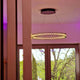 Moderne Deckenleuchte mit schimmernden Lichtern, die an einem Kabel hängen, in einem Raum mit Fenstern.