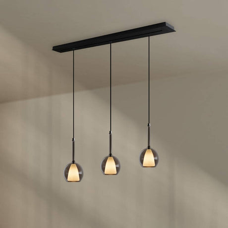 s.luce Belluna 3-flammige Pendelleuchte in Schwarz mit mundgeblasenem Glas über einem Esstisch.