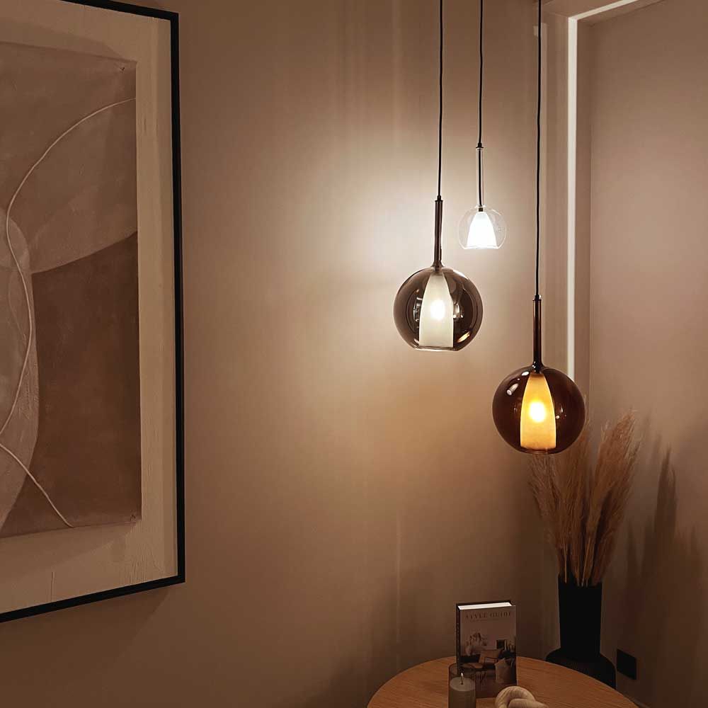 s.luce Belluna Glas-Pendelleuchte 150cm Textilkabel in eleganter Raumgestaltung mit wanddekorativem Licht.