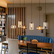s.luce Cruet Low dining table pendant light, single-circuit track end feed above a modern dining table in a stylish room.