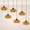 s.luce Cruet mehrflammige Hängeleuchte in modernem Design mit amberfarbenen Lampenschirmen und schlichten Kabeln.