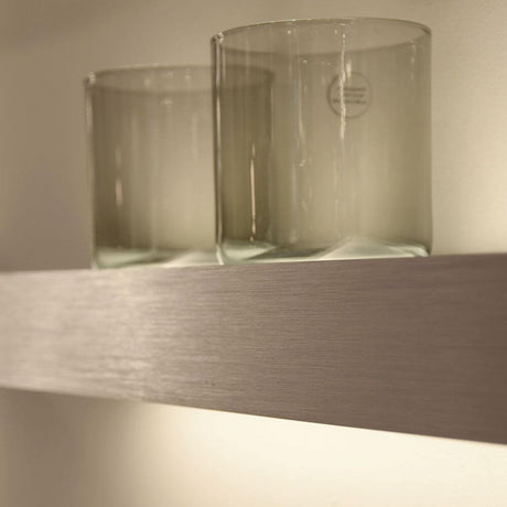 s.luce Cusa LED-lysplate vegglampe Up & Down lyser opp glass på en moderne vegghylle