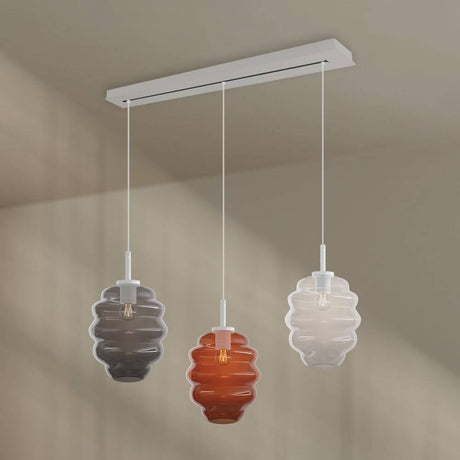 s.luce Echos 3-light dining room pendant light 120cm Ø 25cm with colorful glass bodies above a dining table.