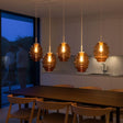 s.luce Echos Esstischlampe 5-flammig in Braun über einem modernen Esstisch, stilvolle Pendelleuchte bei Abenddämmerung.