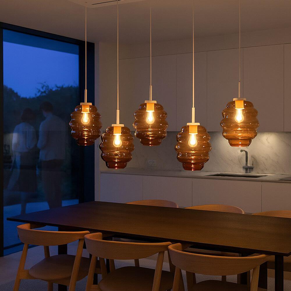 s.luce Echos Esstischlampe 5-flammig in Braun über einem modernen Esstisch, stilvolle Pendelleuchte bei Abenddämmerung.