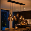 s.luce Echos Esstischleuchte 8-flammig mit mundgeblasenen Glaskörpern, elegantes Lichtdesign über Esstisch.