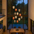 s.luce Echos 12-flammige Pendelleuchte in modernem Wohnraum, elegante Glaskörper in Braun, Rauch und Klar.