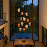 s.luce Echos 12-flammige Pendelleuchte in modernem Wohnraum, elegante Glaskörper in Braun, Rauch und Klar.