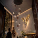 s.luce Echos Galerieleuchte 12-flammig Ø 80cm Baldachin Ø 18/25cm hängende Glas-Pendelleuchte in Cognac, Rauch und Klar über Hotellobby