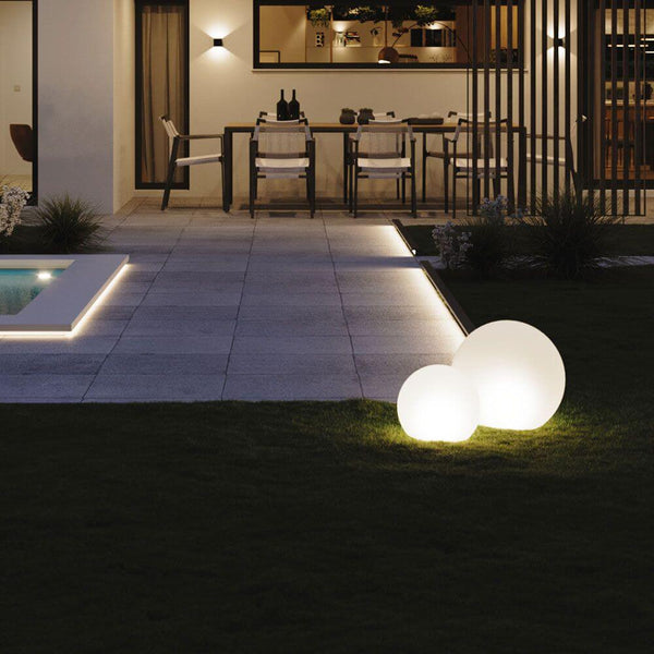 s.luce Globe set garden globe lights on a lawn next to a modern house and a swimming pool.