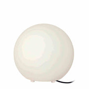 Moderna lámpara de mesa redonda de vidrio blanco con forma minimalista y cable.