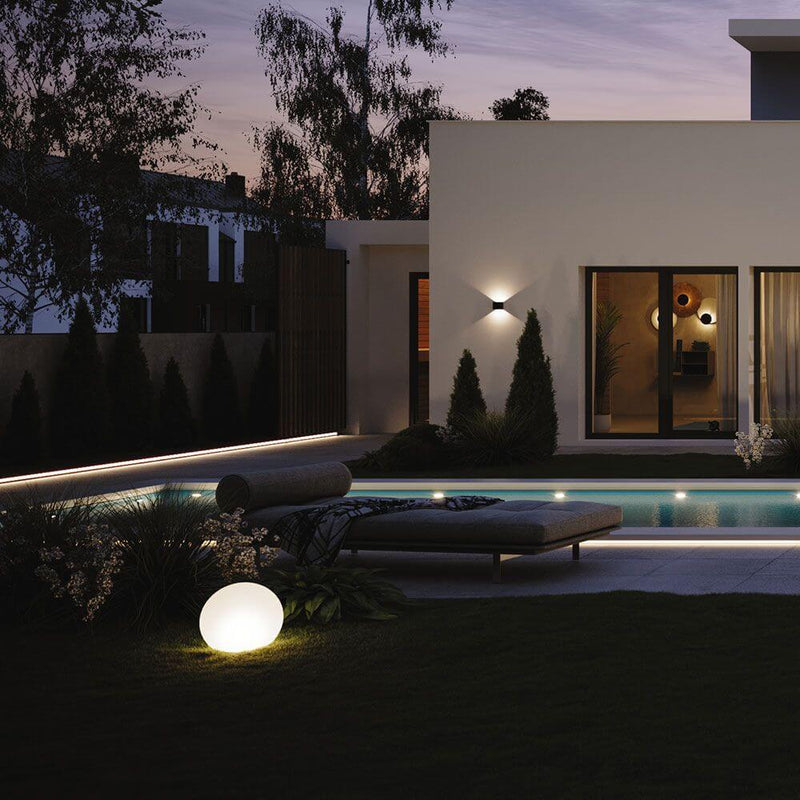 s.luce Ixa LED applique murale angles réglables intérieur & extérieur IP44 dans un espace extérieur moderne avec piscine.