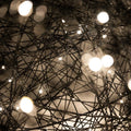 Nahaufnahme der s.luce Mesh Drahtkugel mit warmweißen LED-Lichtern, die ein magisches Ambiente schaffen.