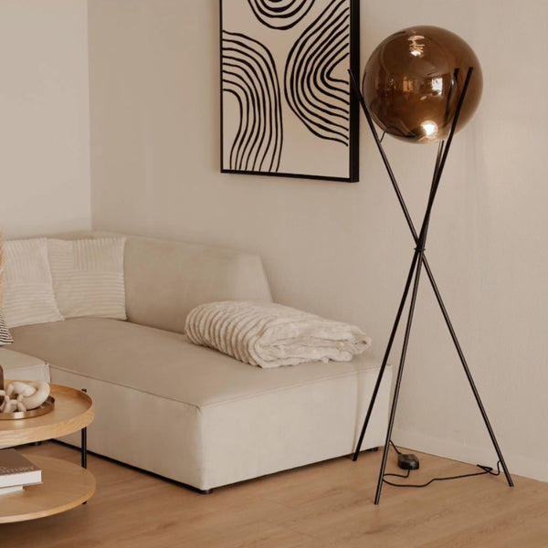 s.luce Orb Axis Glaskugel Stehlampe Dreibein 160cm im modernen Wohnzimmer mit goldenem Glasschirm und Fußdimmer