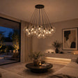 s.luce Orb Cluster Glas-Pendelleuchte 13-flammig 13x20cm im modernen Wohnzimmer mit glamouröser Lichtatmosphäre.